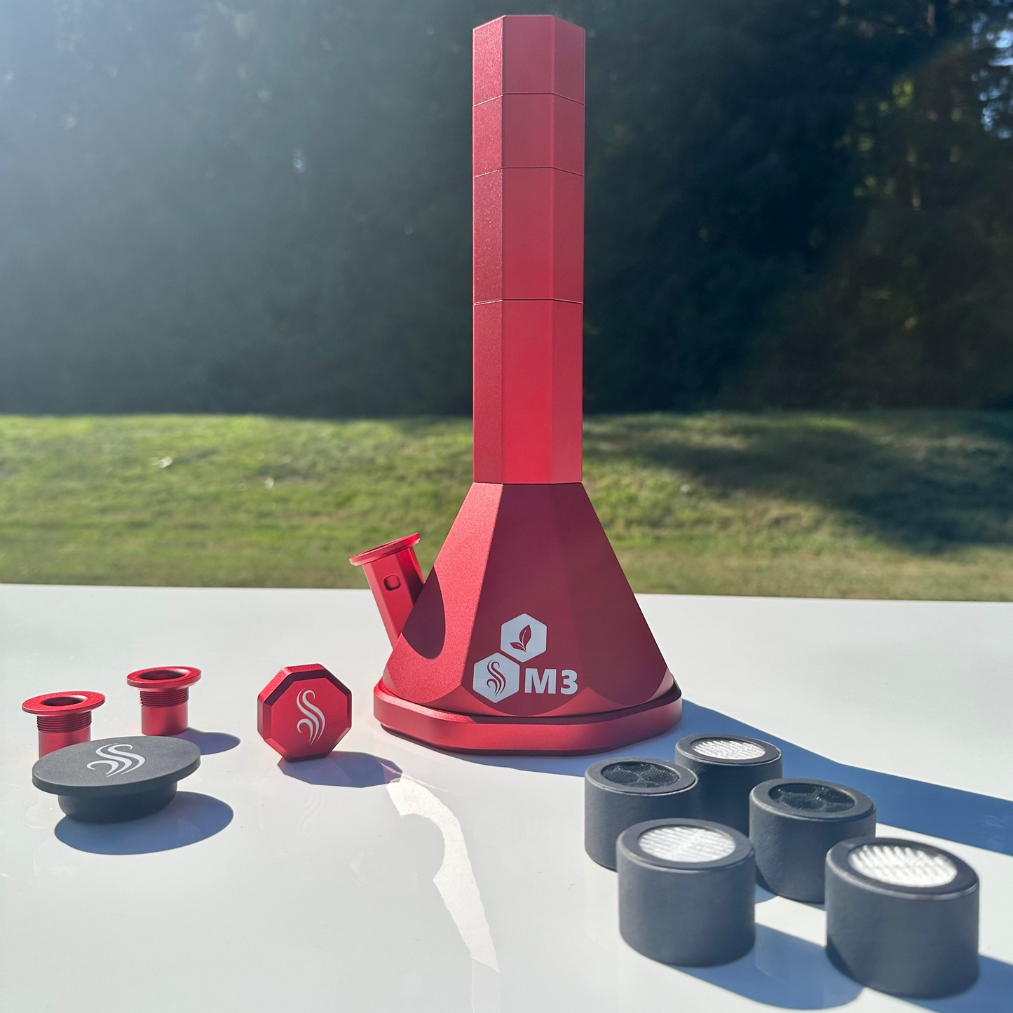 Red M3 Pro Bong with accessories and 5 M2/M3 M Series filters on a white surface outdoors