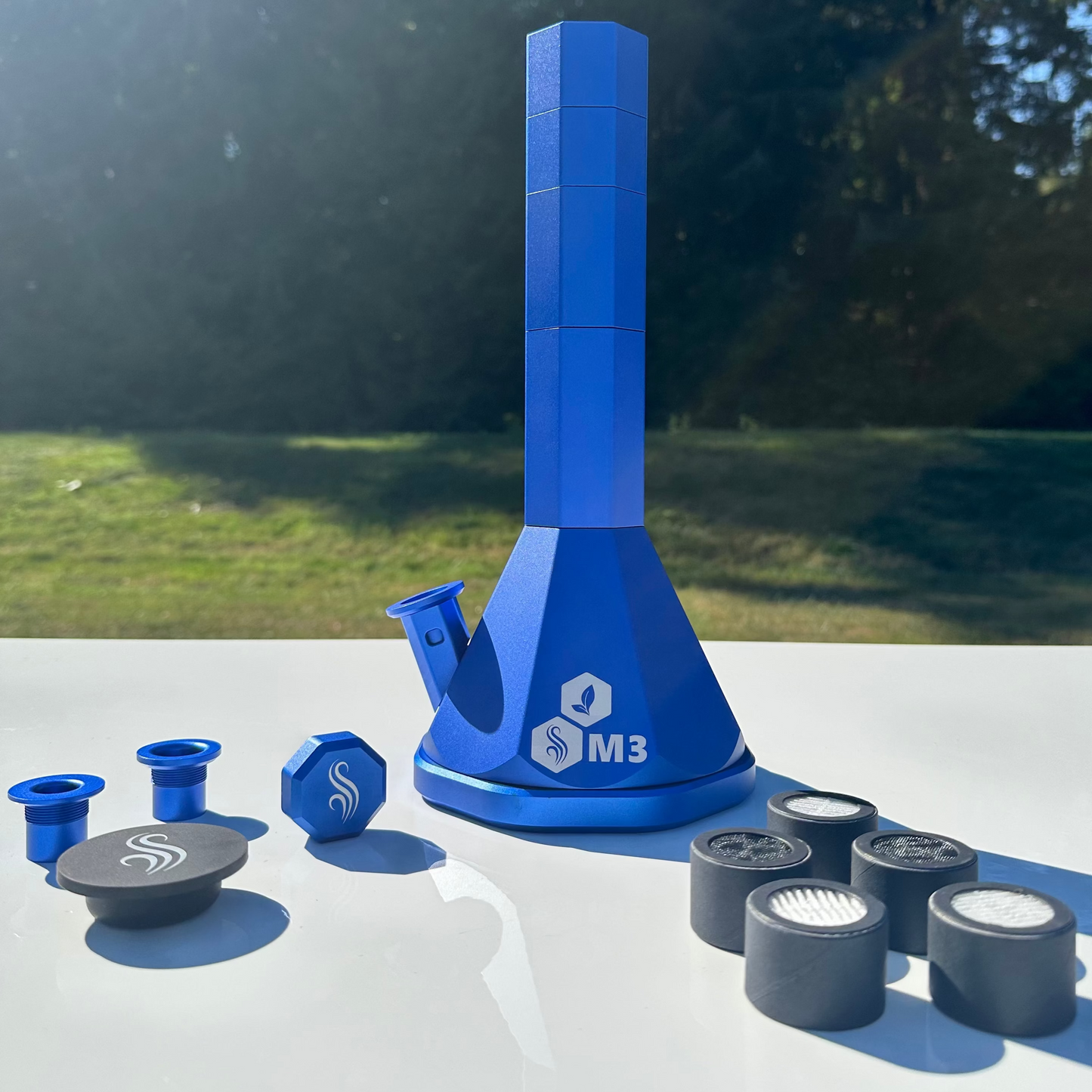 Blue M3 Pro Bong with accessories and 5 M2/M3 M Series filters on a white surface outdoors