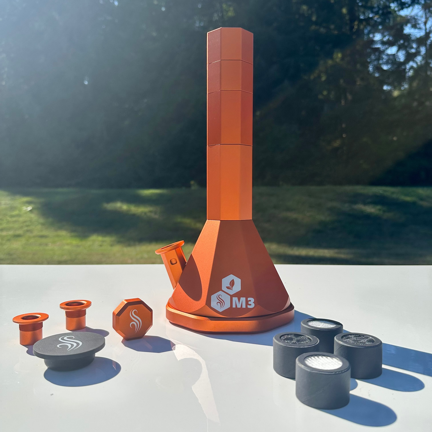 Orange M3 Pro with accessories and 3 filters on a white surface outdoors