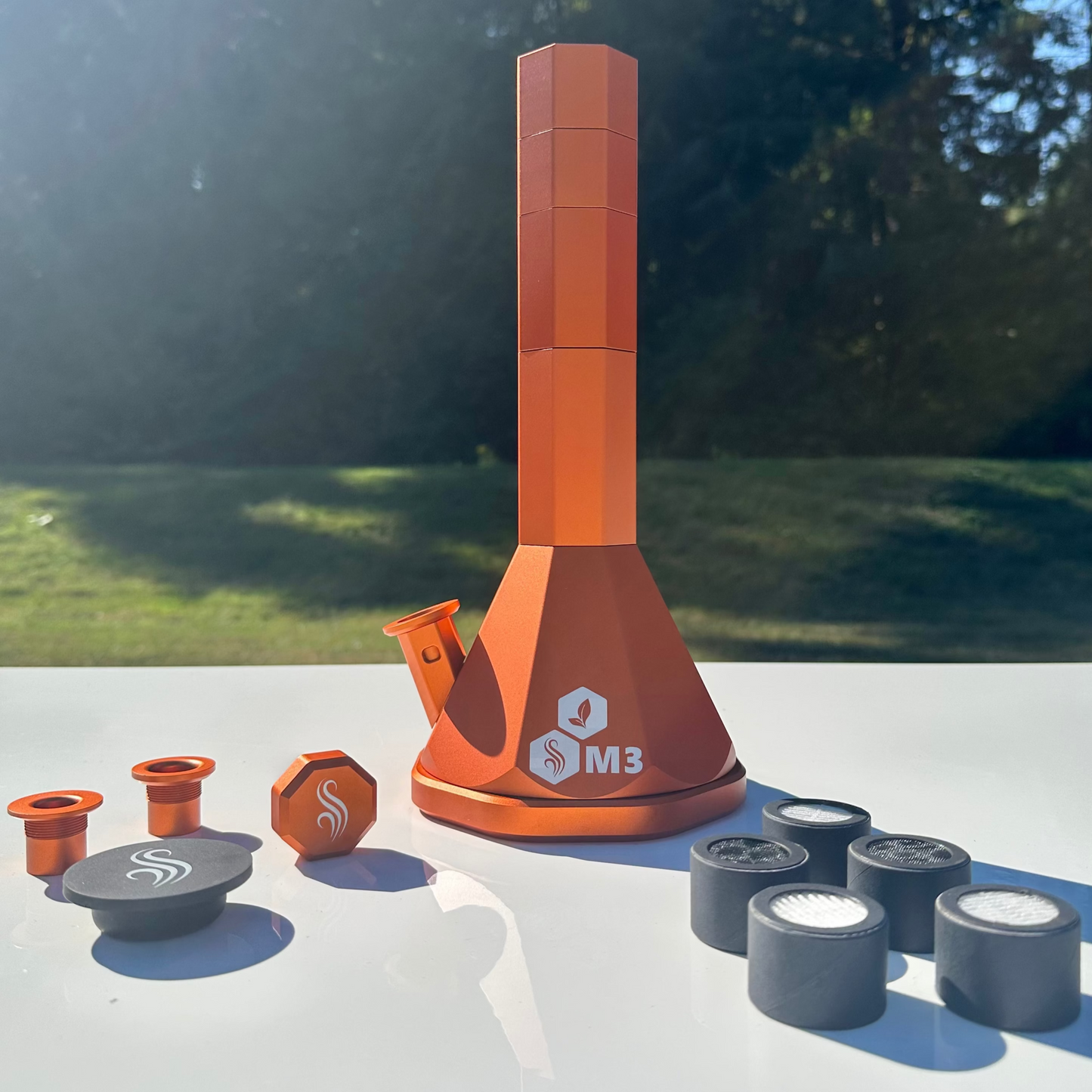 Orange M3 Pro with accessories and 5 filters on a white surface outdoors