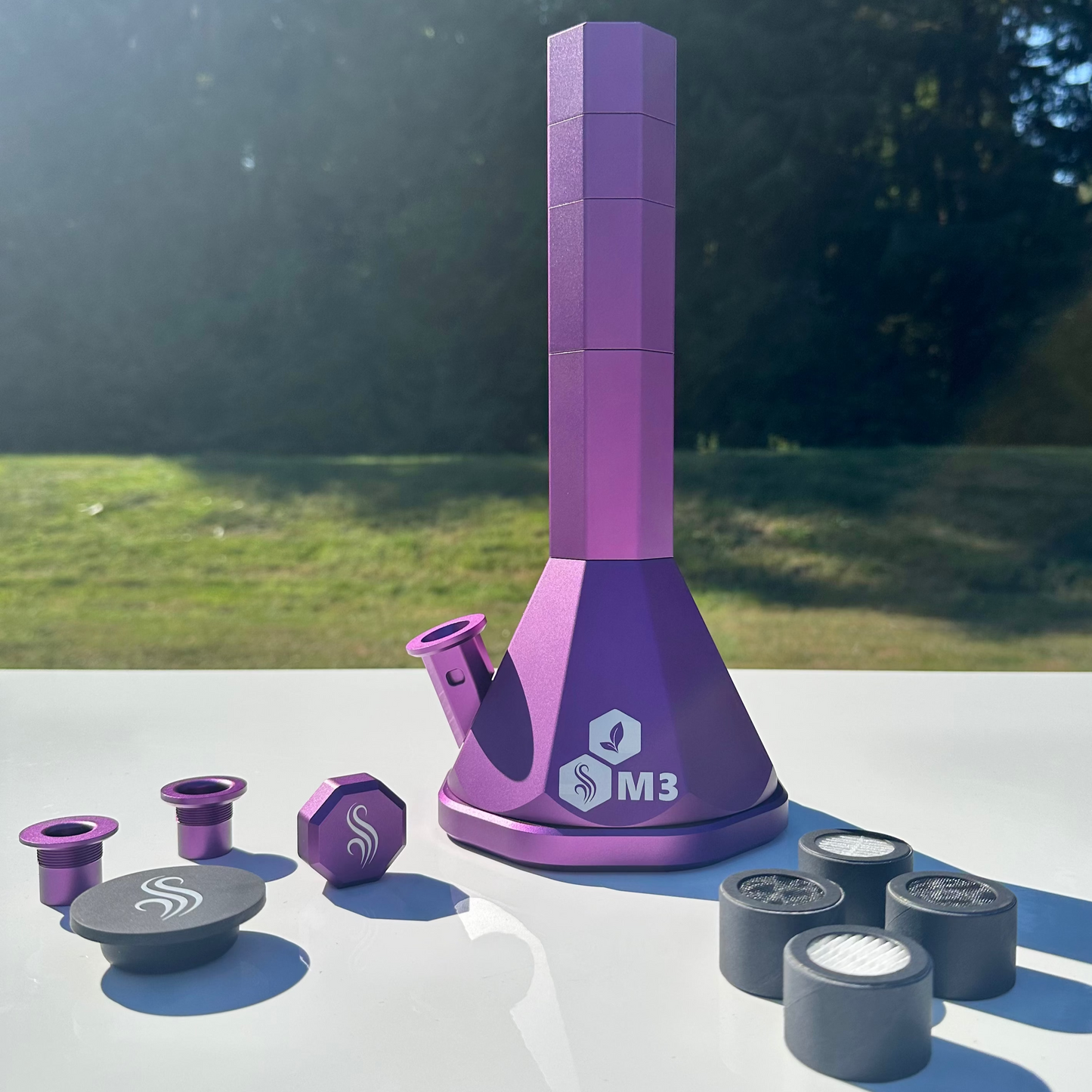 Purple M3 Pro Bong with accessories and 4 M2/M3 M Series filters on a white surface outdoors